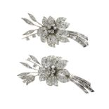 A PAIR OF GRADUATED DIAMOND FLOWER BROOCHES in white gold or platinum, each designed as a spray of