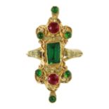 A JEWELLED MUGHAL STYLE DRESS RING in 18ct yellow gold set with green and red gemstones within