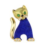 A LAPIS LAZULI, DIAMOND AND EMERALD CAT BROOCH in 18ct yellow gold, the flat carved lapis lazuli