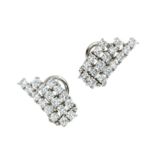 A PAIR OF DIAMOND EARRINGS in white gold or platinum, each set with three rows of round cut diamonds