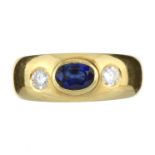 A BLUE SAPPHIRE AND DIAMOND THREE STONE RING in 18ct yellow gold set with a central oval blue