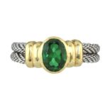 A TOURMALINE DRESS RING in yellow and white gold, the oval green tourmaline collet set between