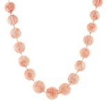 A CHINESE CORAL BEAD NECKLACE comprising a single row of thirty two graduated carved coral beads