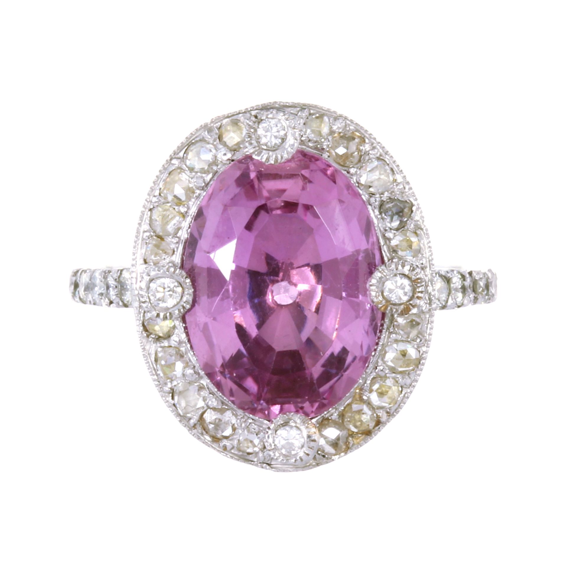 A PINK TOPAZ AND DIAMOND RING in platinum set with a central oval cut pink topaz of 6.25 carats