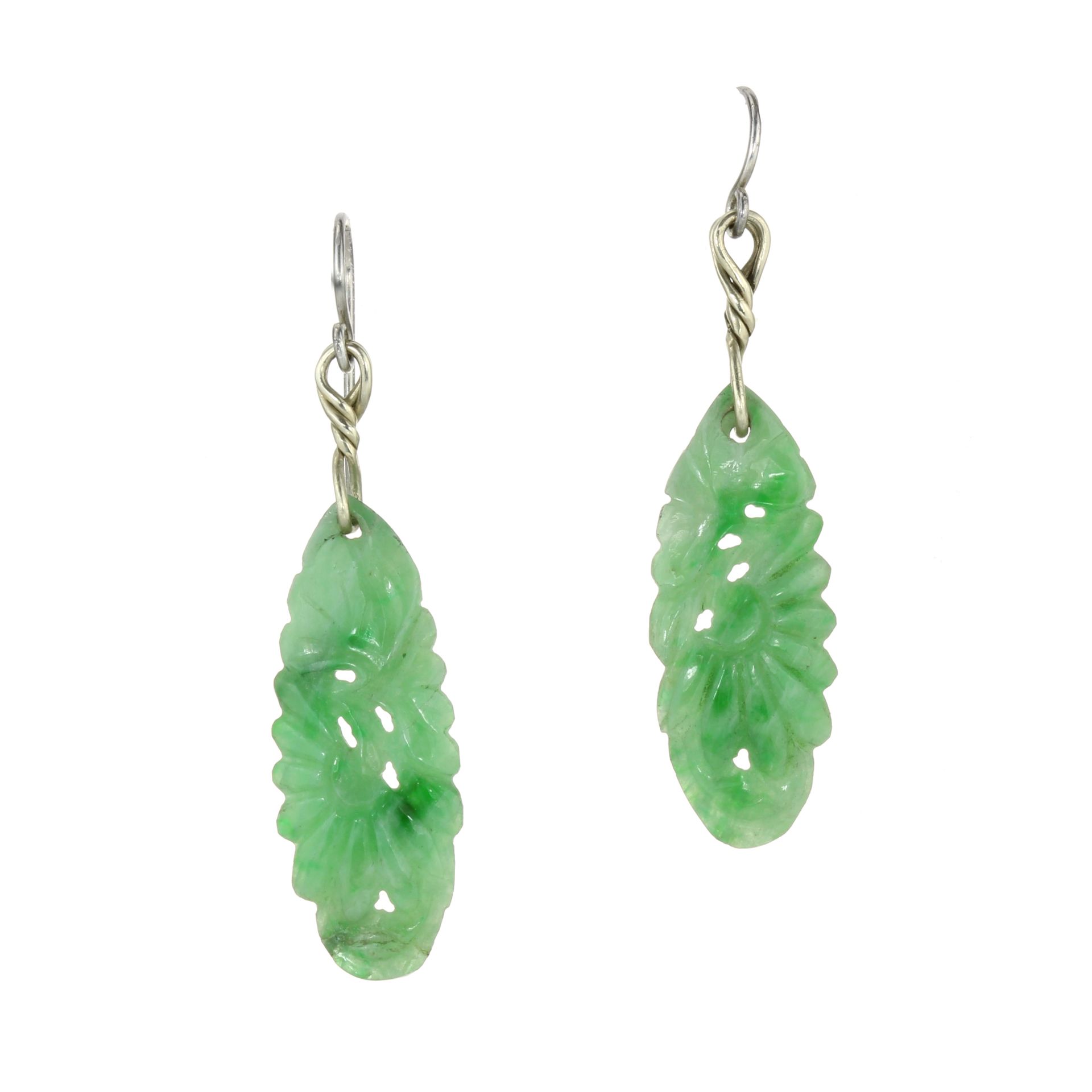 AN PAIR OF CARVED JADE EARRINGS in white gold and silver, each set with an elongated carved piece of