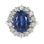 A BURMA NO HEAT BLUE SAPPHIRE AND DIAMOND CLUSTER RING in platinum, set with a central oval cut blue