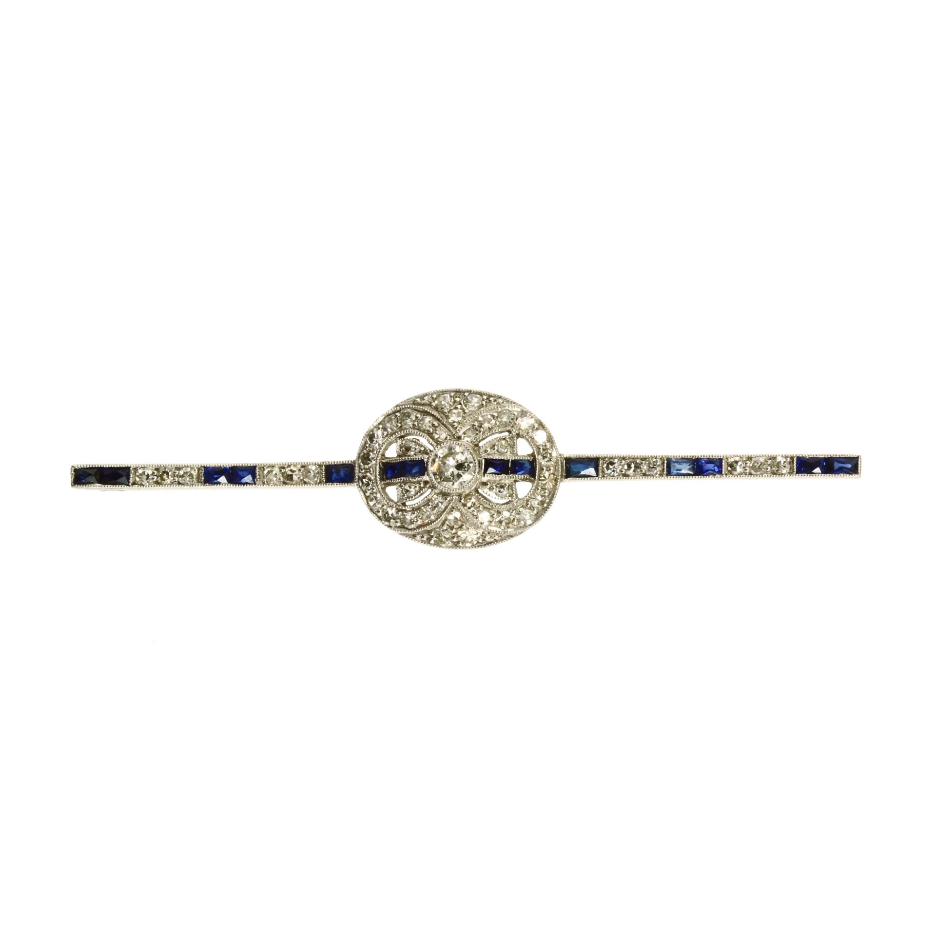 AN ART DECO DIAMOND AND SAPPHIRE BAR BROOCH in platinum or white gold, the oval motif set with a