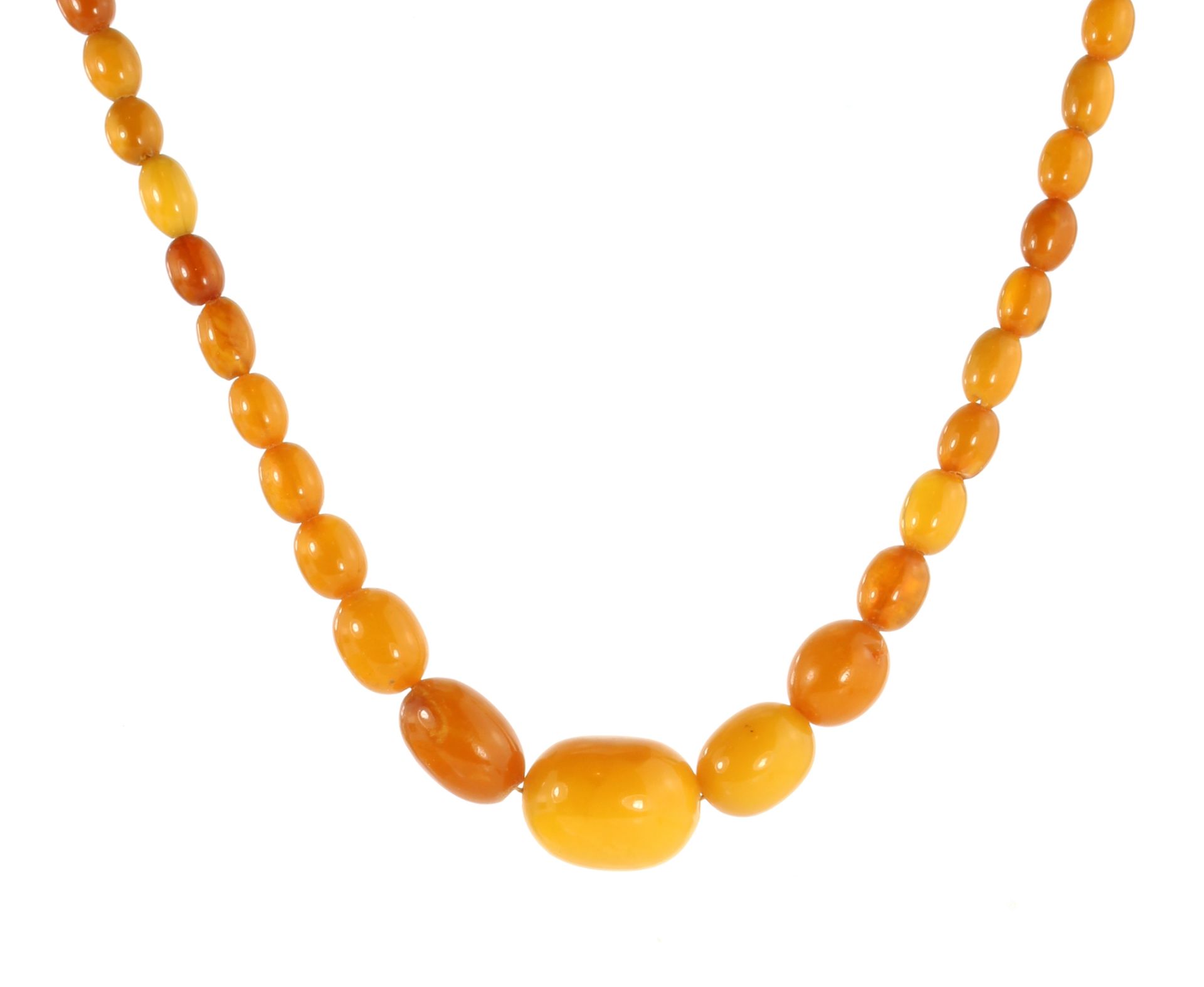 A NATURAL AMBER BEAD NECKLACE comprising a single row of sixty graduated polished oval beads up to