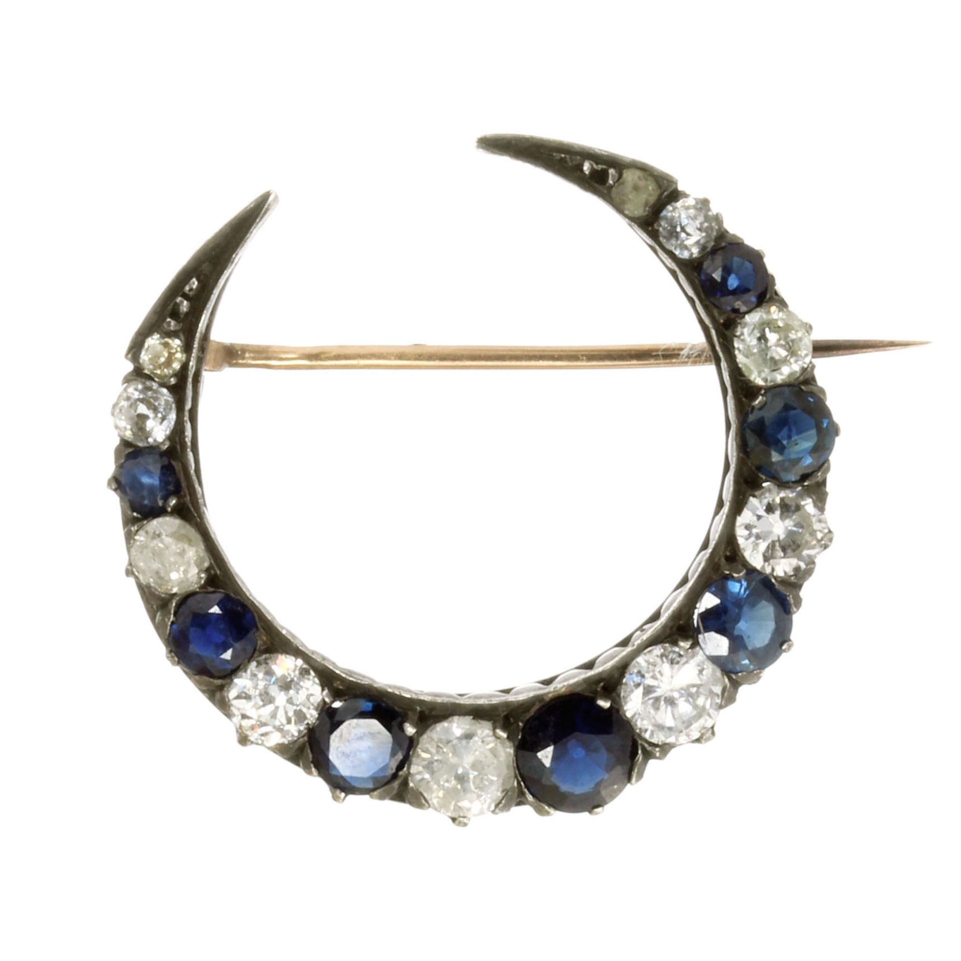 AN ANTIQUE BLUE SAPPHIRE AND DIAMOND CRESCENT BROOCH in 18ct yellow gold and silver, designed as a