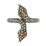 A RUBY AND DIAMOND SNAKE RING designed as two snakes' heads coiled next to each other, jewelled with