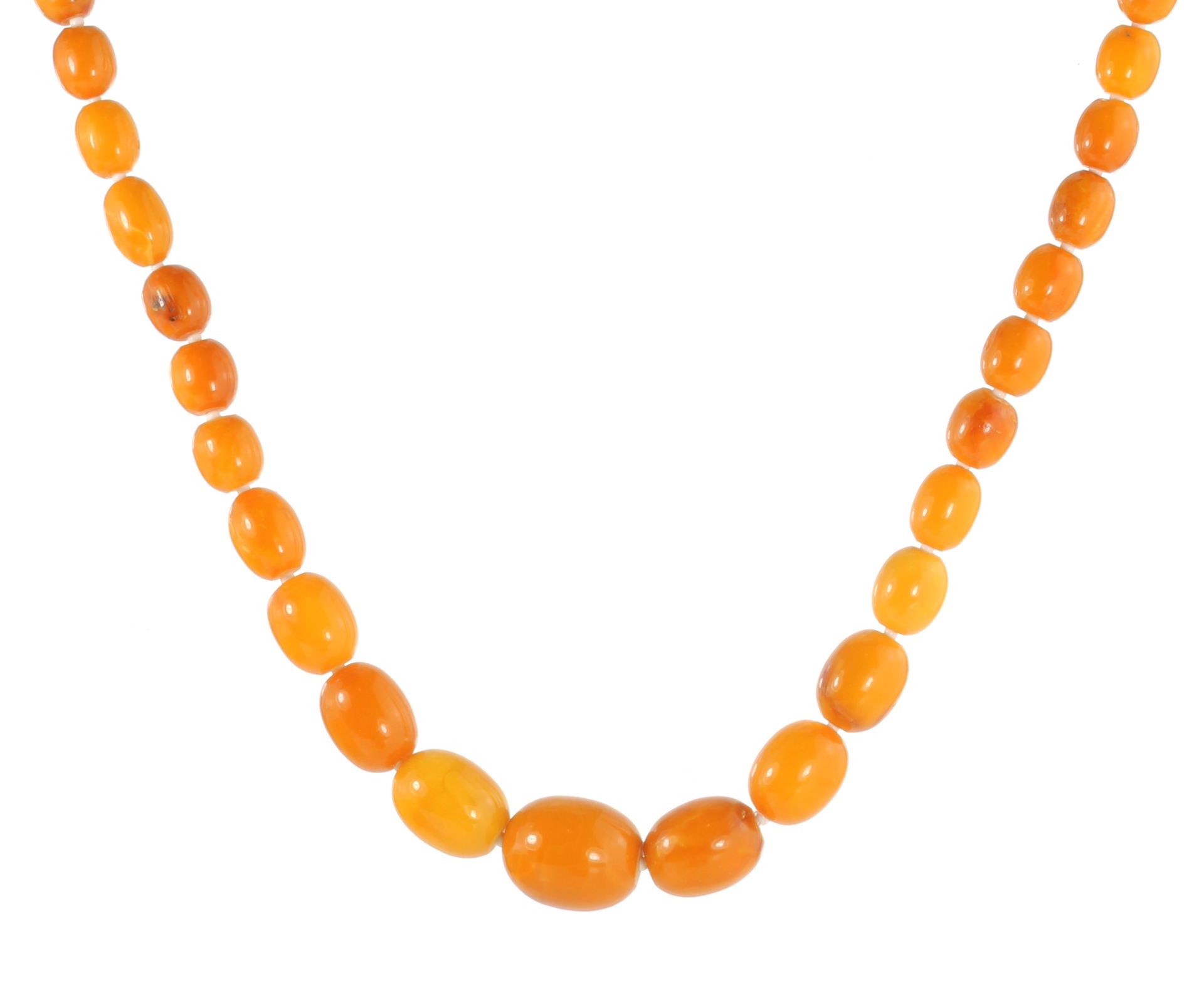 AN NATURAL AMBER BEAD NECKLACE comprising a single row of sixty-eight graduated polished oval