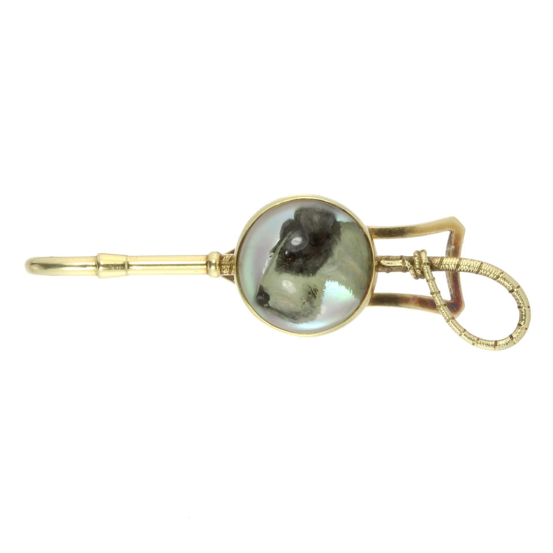 AN ANTIQUE ESSEX CRYSTAL DOG AND RIDING CROP TIE CLIP in high carat yellow gold, the riding crop set