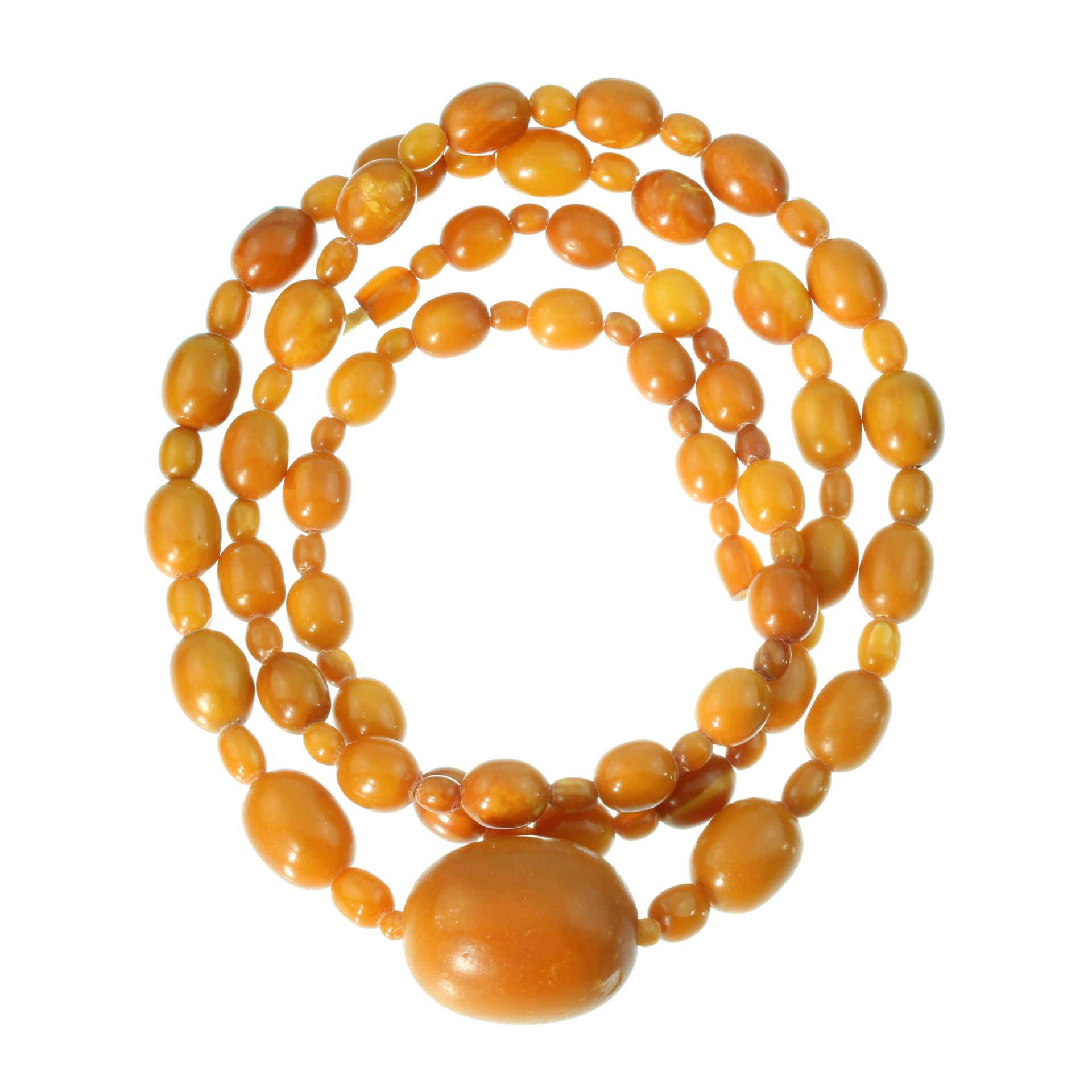 AN ANTIQUE NATURAL AMBER NECKLACE with a large oval bead of 39mm within a single row of ninety-six