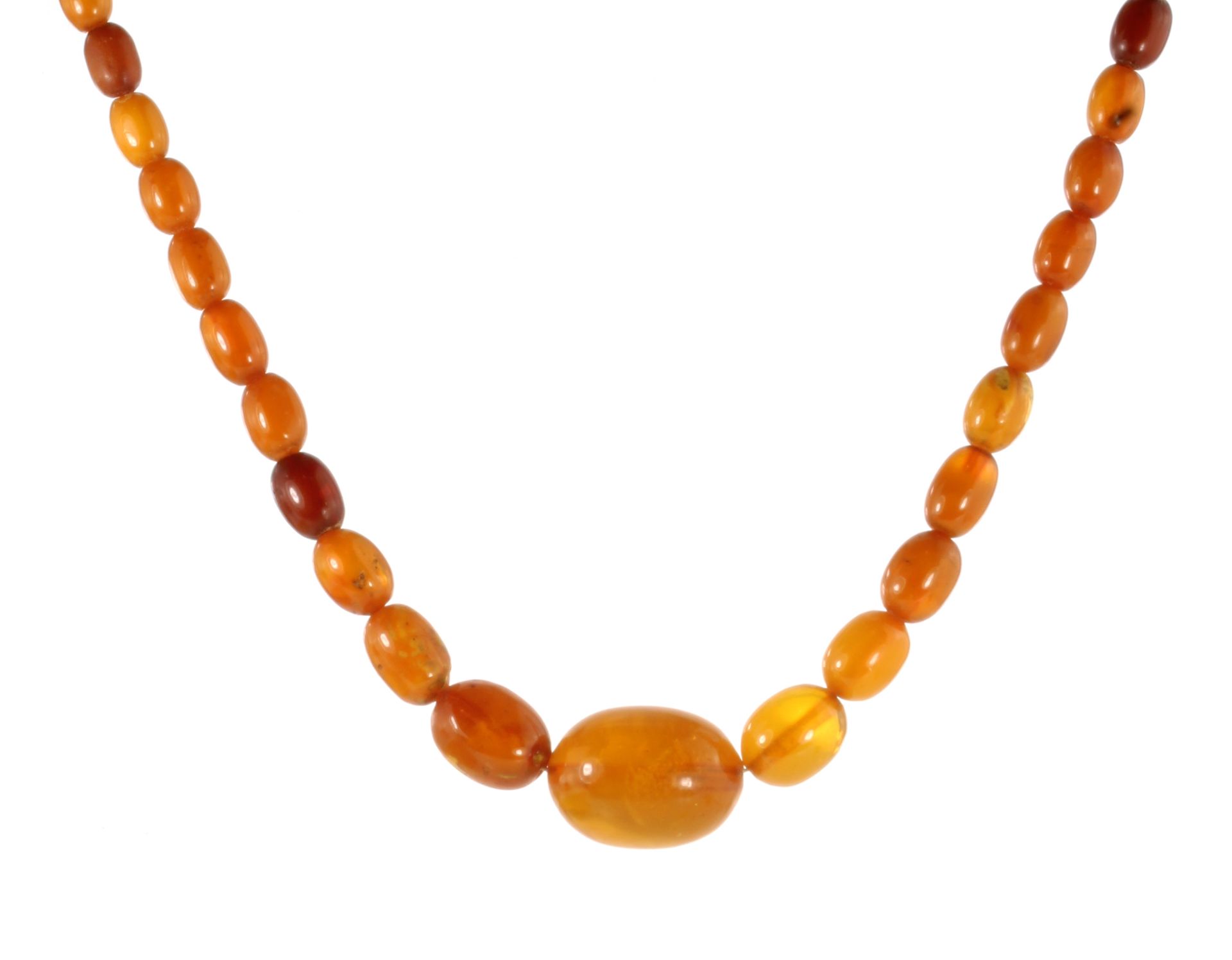 A NATURAL AMBER BEAD NECKLACE comprising a single row of forty-one graduated polished oval beads