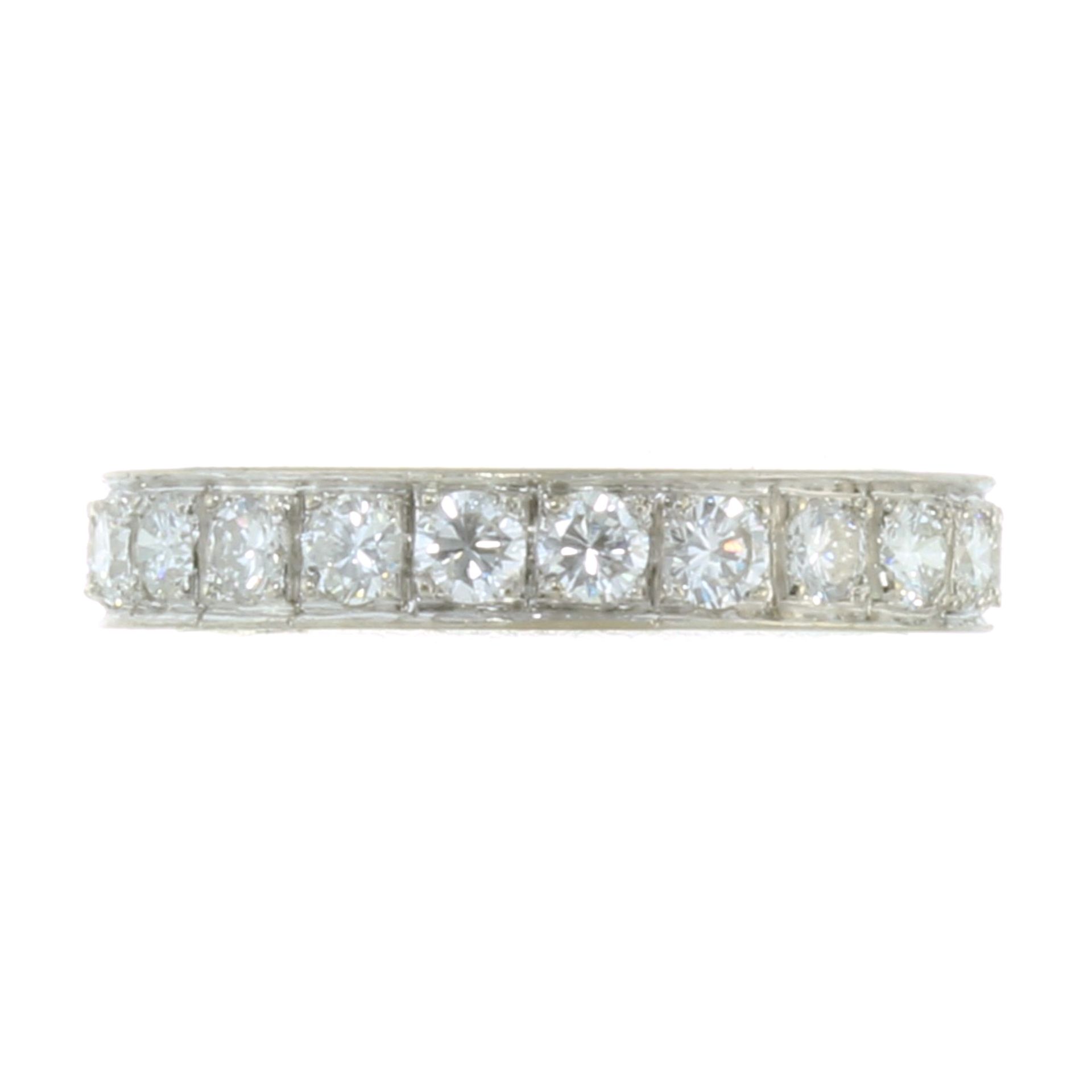 A DIAMOND ETERNITY RING in white gold or platinum, the band set completely around with round cut