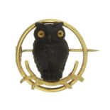 A WOODEN OWL BROOCH, EARLY 20TH CENTURY in yellow gold, designed as a carved wooden owl with glass