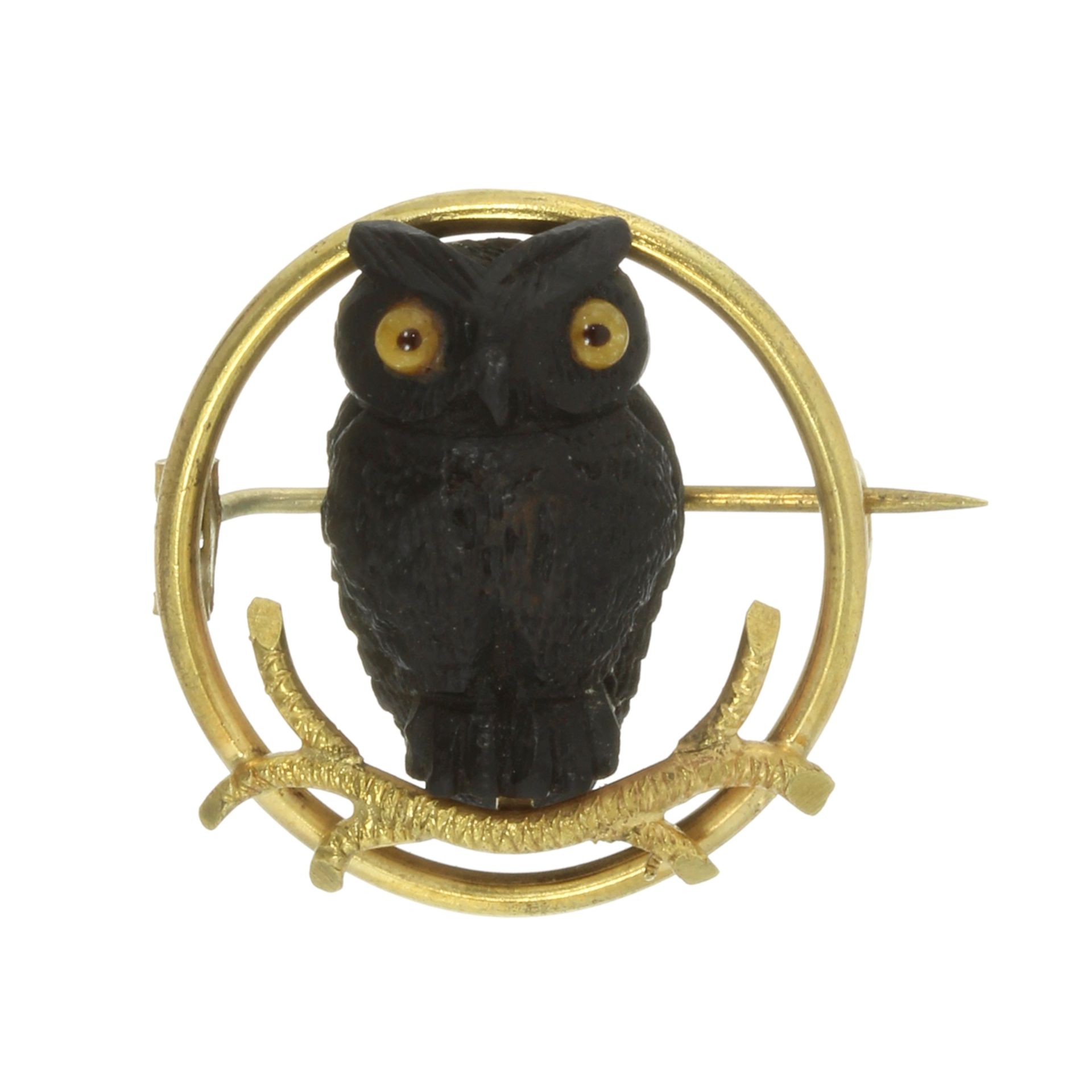 A WOODEN OWL BROOCH, EARLY 20TH CENTURY in yellow gold, designed as a carved wooden owl with glass