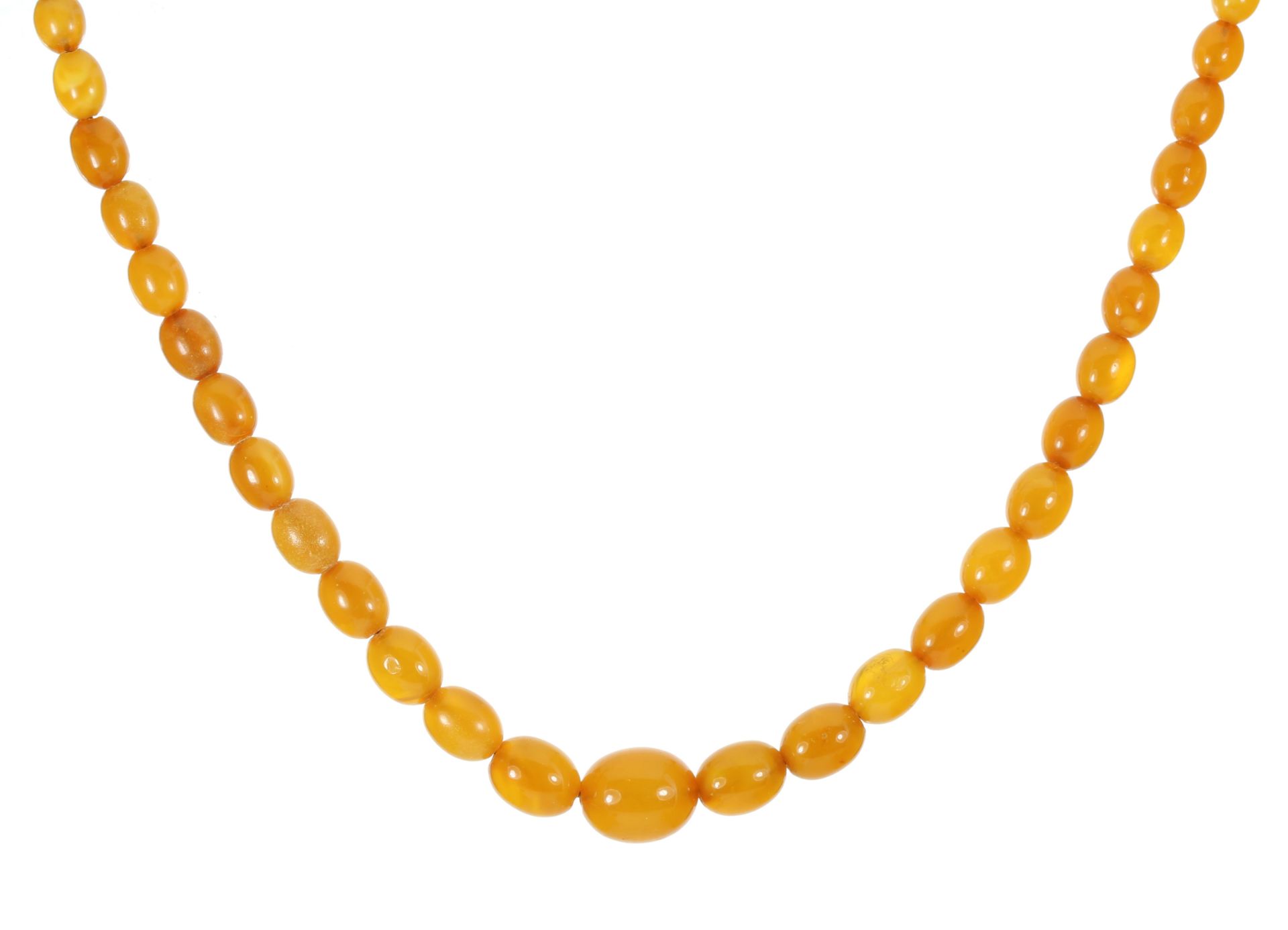 A NATURAL AMBER BEAD NECKLACE comprising a single row of fifty graduated polished oval beads up to