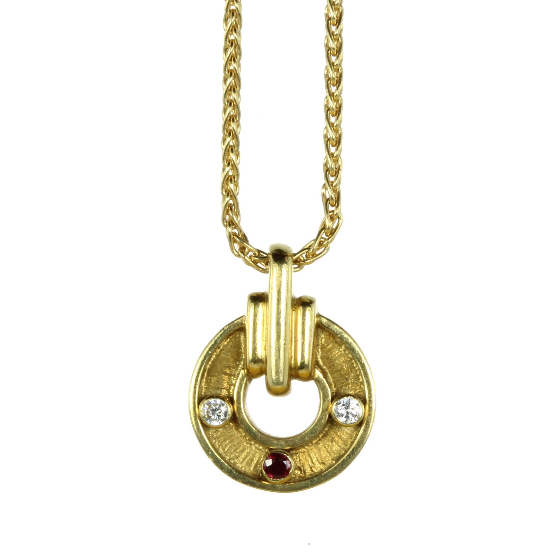 A VINTAGE RUBY AND DIAMOND PENDANT, KUTCHINSKY in 18ct yellow gold, the circular motif with textured