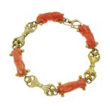 AN ANTIQUE CARVED CORAL BRACELET in yellow gold, comprising alternating carved coral links in the