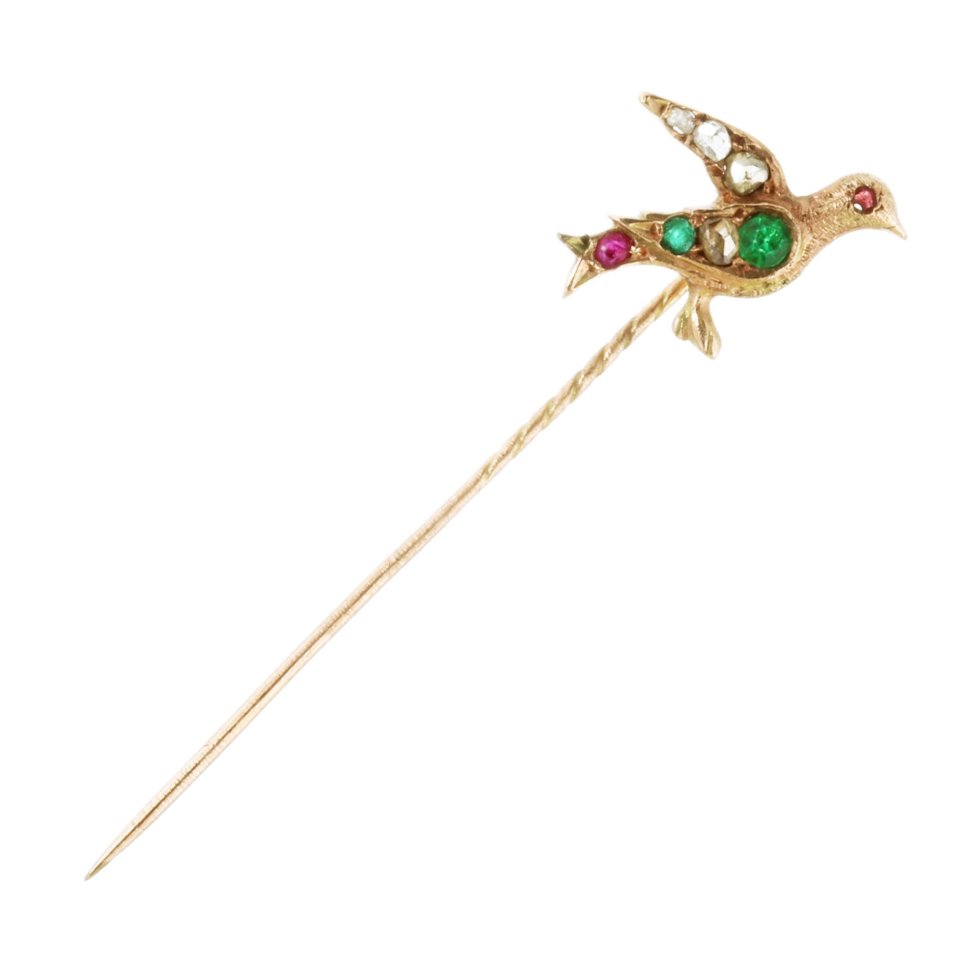 AN ANTIQUE EMERALD, DIAMOND AND RUBY BIRD TIE / STICK PIN in high carat yellow gold, designed as a