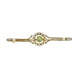 AN ANTIQUE PERIDOT AND SEED PEARL BROOCH in high carat yellow gold set with a central round cut