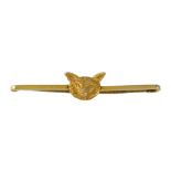 AN ANTIQUE FOX BAR BROOCH in yellow gold, the simple bar set at the centre with the head of a fox,