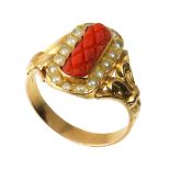 A CORAL AND PEARL DRESS RING in high carat yellow gold, set with a central piece of carved coral