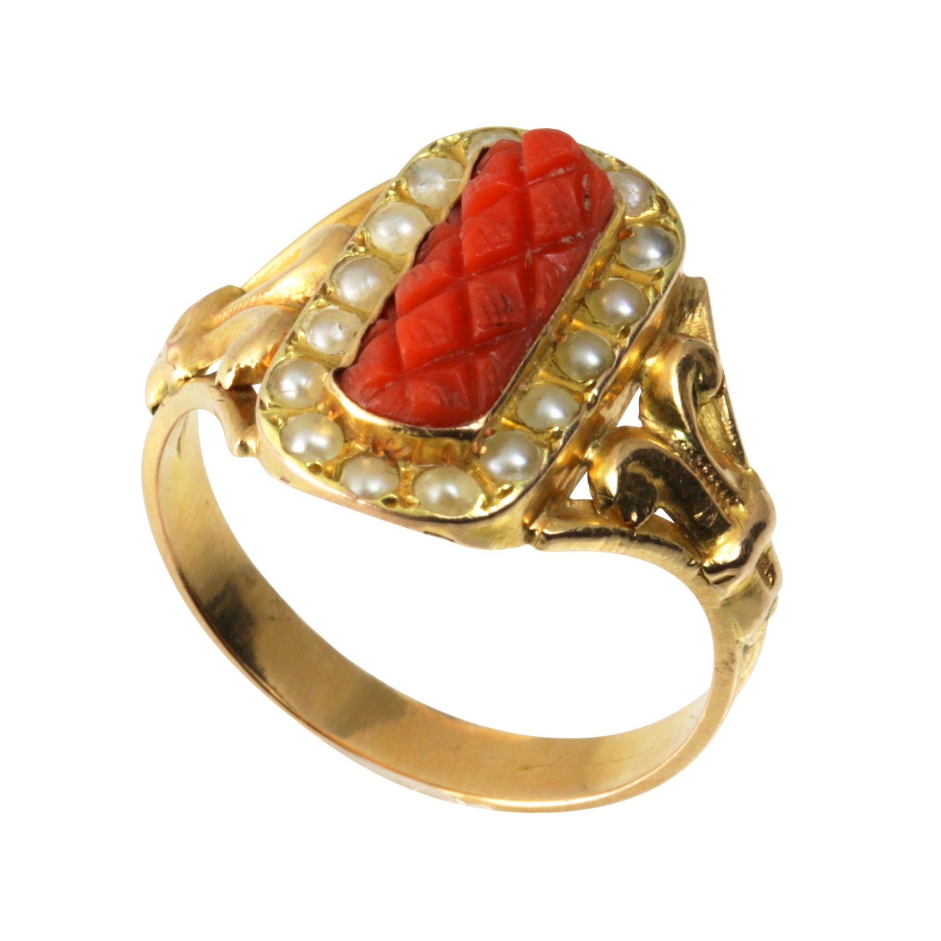 A CORAL AND PEARL DRESS RING in high carat yellow gold, set with a central piece of carved coral