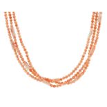 A THREE ROW CORAL BEAD NECKLACE in yellow gold, comprising three rows of two hundred and seventy