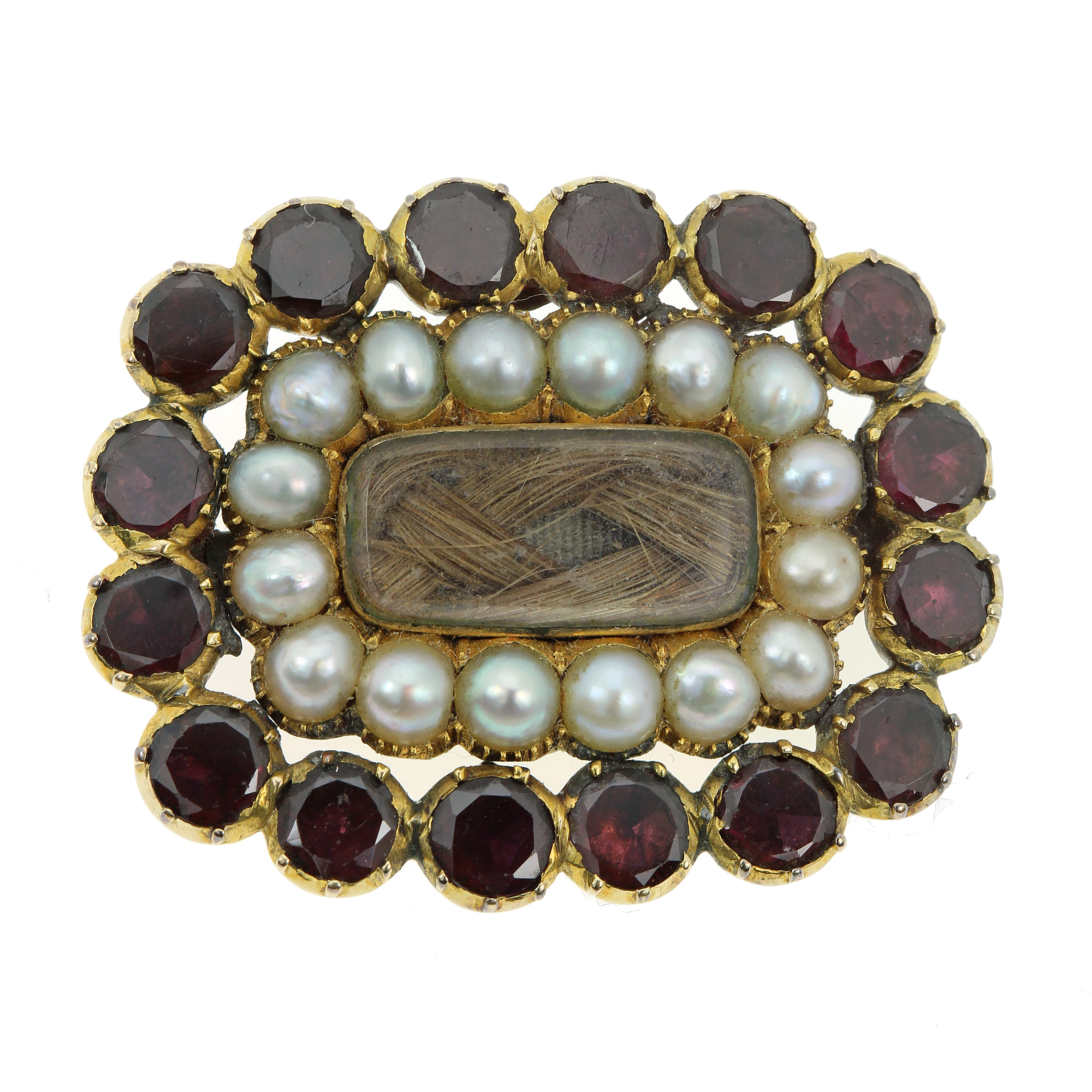 AN ANTIQUE GARNET, SEED PEARL AND HAIRWORK MOURNING BROOCH in high carat yellow gold set with a