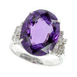 AN AMETHYST AND DIAMOND DRESS RING in white gold set with an oval cut amethyst of 9.45 carats