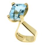 AN AQUAMARINE COCKTAIL RING, 1980 in 18ct yellow gold, set with a central emerald cut aquamarine