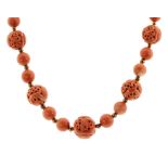 AN ANTIQUE CHINESE CARVED CORAL BEAD NECKLACE in yellow gold, comprising a single row of forty-