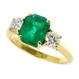 AN EMERALD AND DIAMOND THREE STONE RING in 18ct yellow gold, set with a central emerald cut