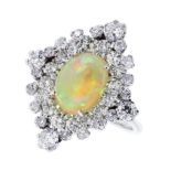 AN OPAL AND DIAMOND DRESS RING in 18ct white gold set with a central cabochon opal surrounded by