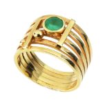 AN EMERALD DRESS RING in high carat yellow gold, the split band set with a round cut emerald between