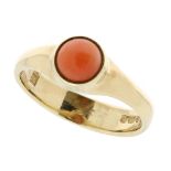 A CORAL DRESS RING in yellow gold, the tapering band set with a single round coral cabochon, full