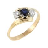 A SAPPHIRE AND DIAMOND THREE STONE RING in high carat yellow gold, set with a central sapphire of