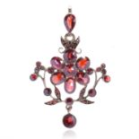 AN ANTIQUE GARNET PENDANT in yellow gold, designed as a flower set with round and oval rose cut