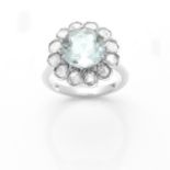 AN AQUAMARINE AND DIAMOND CLUSTER RING in 18ct white gold, set with a central round cut aquamarine