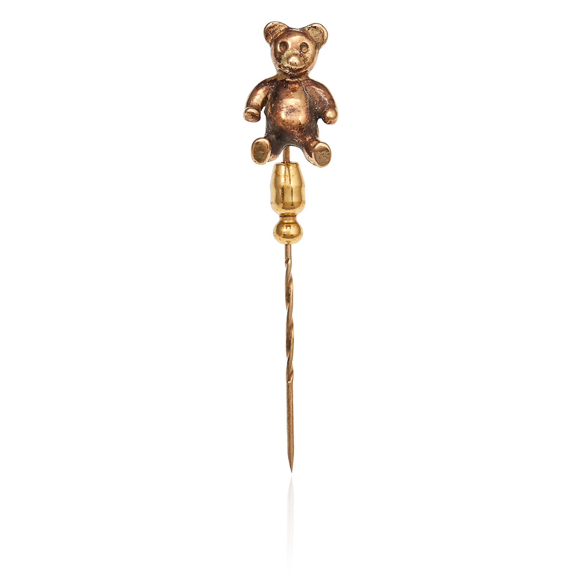 AN ANTIQUE TEDDY BEAR TIE / STICK PIN in yellow gold, the pin surmounted by a gold bear,