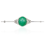 A JADE AND DIAMOND BAR BROOCH in white gold or platinum, set with a central oval jade cabochon