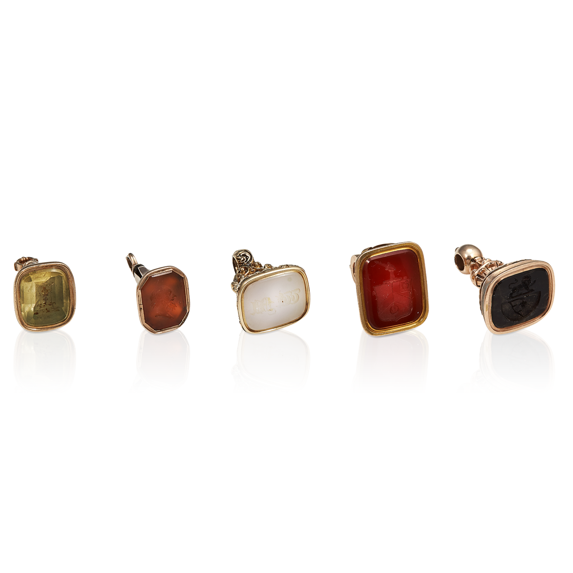 FIVE HARD STONE INTAGLIO SEALS in yellow gold, set with a range of hard-stones including