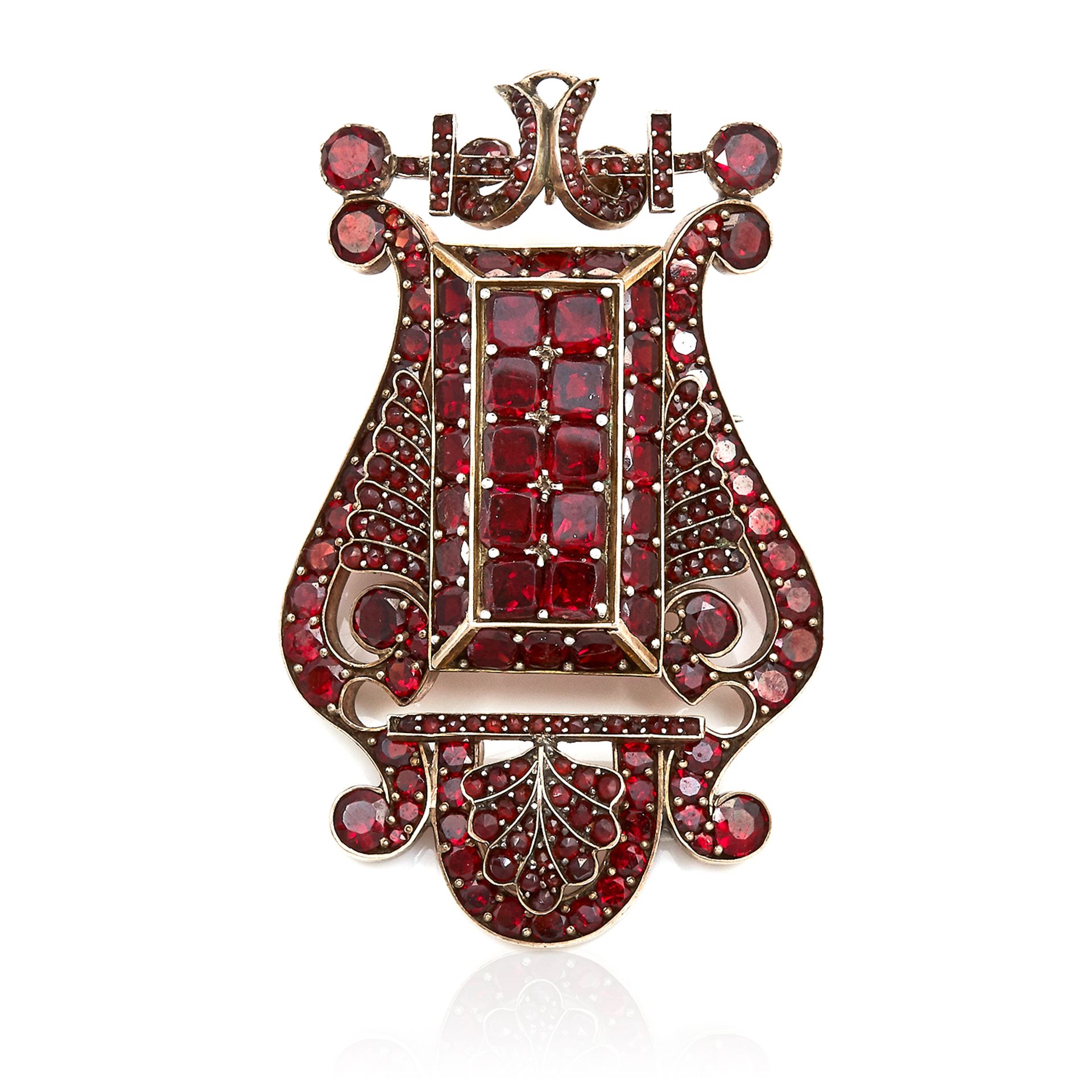 AN ANTIQUE GARNET PENDANT / BROOCH in yellow gold, set with round and flat cut garnets, apparently