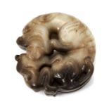 A CHINESE JADE DOG AND BABY DISC PENDANT of circular form, depicting a baby, its head held in the