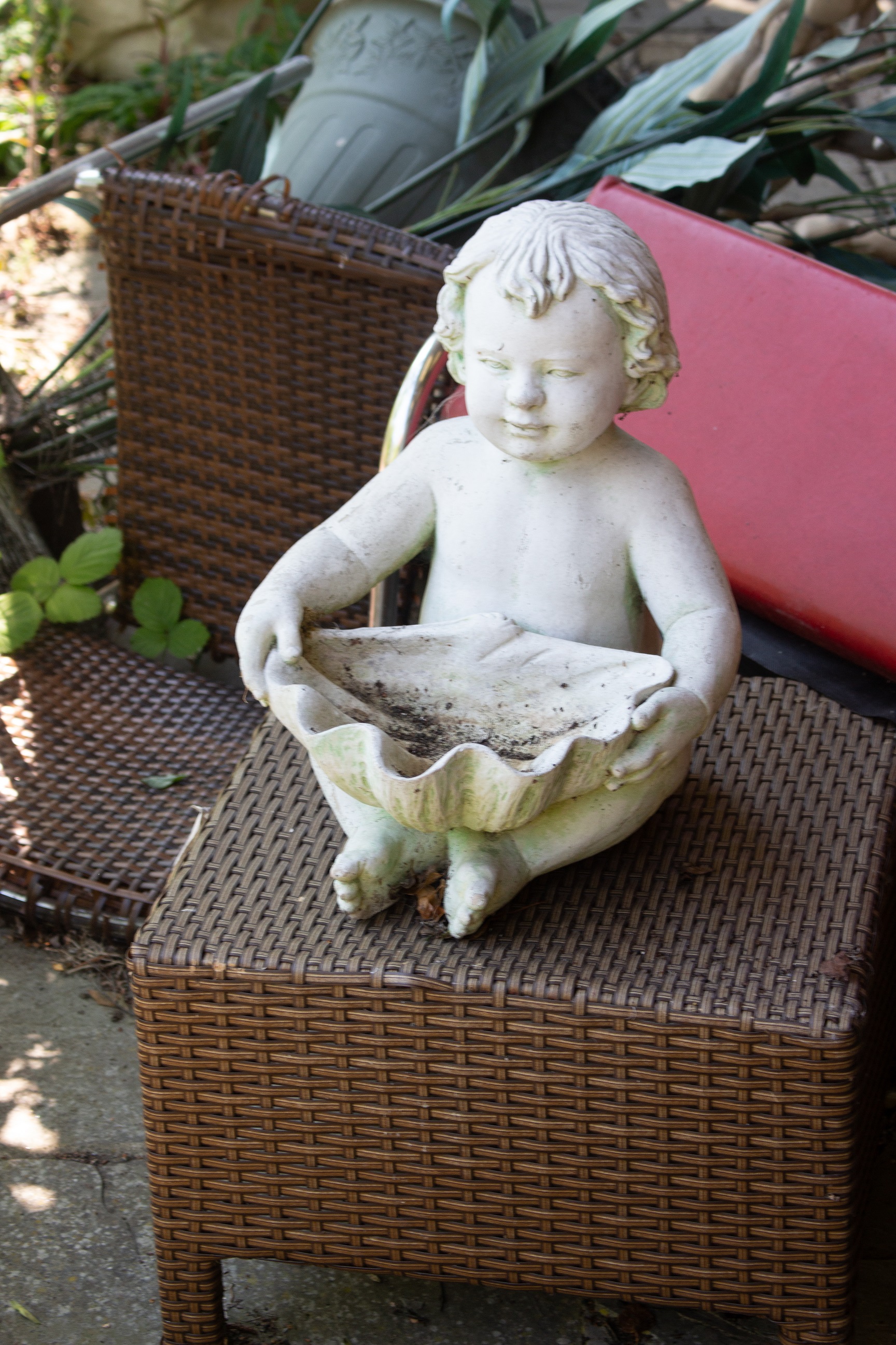 Resin baby holding large leaf