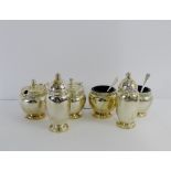 George VI silver condiment set comprising two pepper pots, two salts and two mustards, complete with