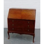 A mahogany veneered bureau, the fall front opening to reveal a fitted interior, with pull out slides