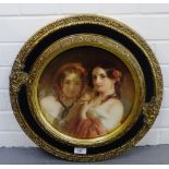 A framed coloured print of two girls in a circular ebonised and gilt wood frame, 28cm diameter